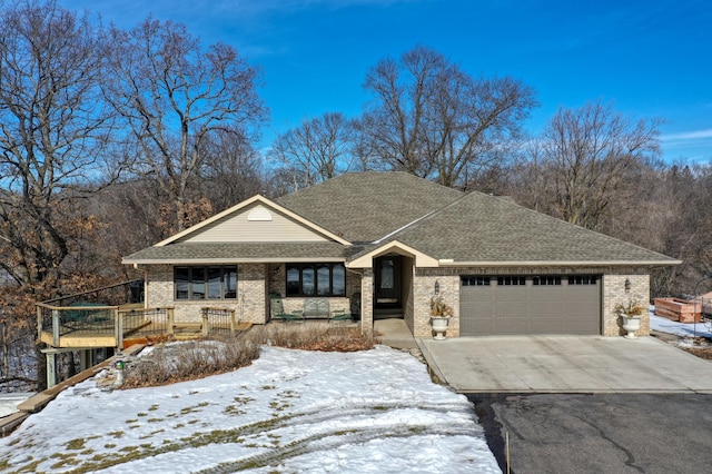 view of front facade with concrete driveway, roof with shingles, brick siding, and an attached garage