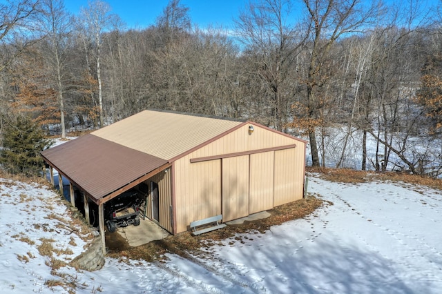 snow covered structure with a pole building and an outdoor structure