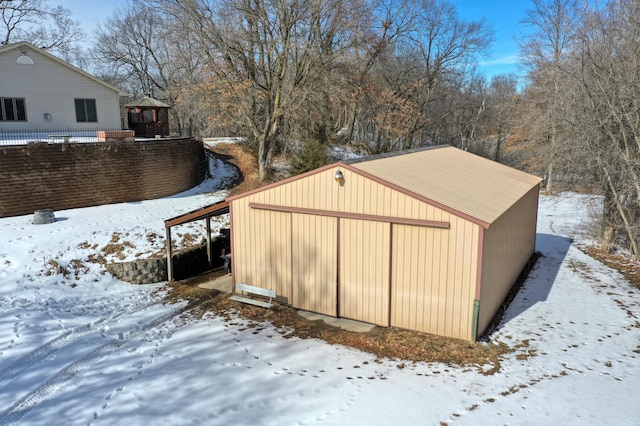 snow covered structure with a pole building and an outdoor structure