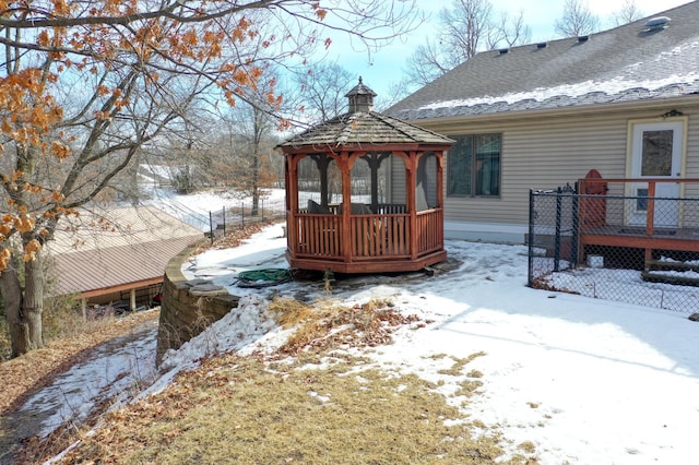 exterior space with a shingled roof, a deck, and a gazebo