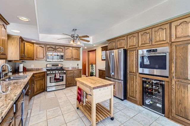 10740 230th St N, Scandia, MN 55073 - kitchen with appliances with stainless steel finishes, wine cooler, a tray ceiling, light stone counters, and light tile patterned flooring