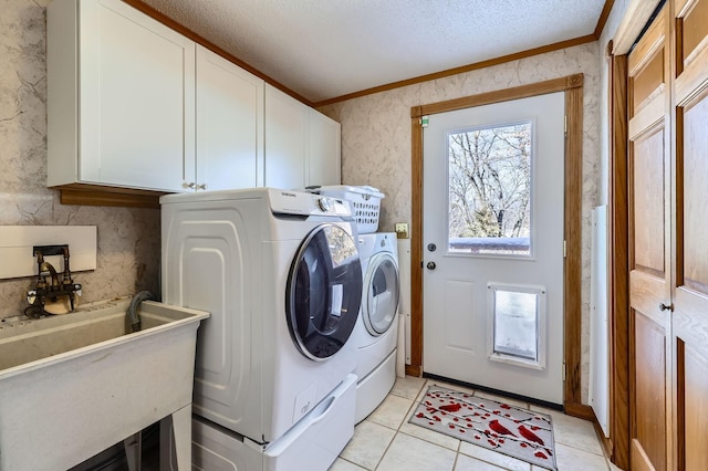 10740 230th St N, Scandia, MN 55073 - laundry room featuring cabinet space, ornamental molding, washing machine and clothes dryer, a textured ceiling, and light tile patterned floors