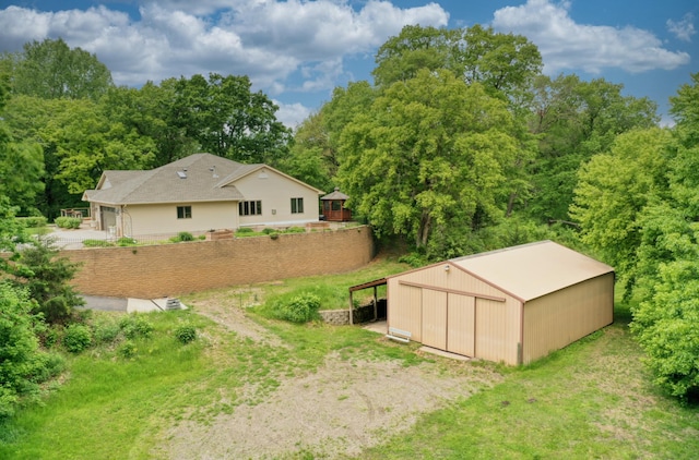10740 230th St N, Scandia, MN 55073 - view of yard featuring an outbuilding, an outdoor structure, a wooded view, and a garage