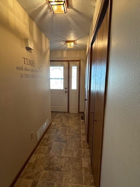 doorway with a textured ceiling