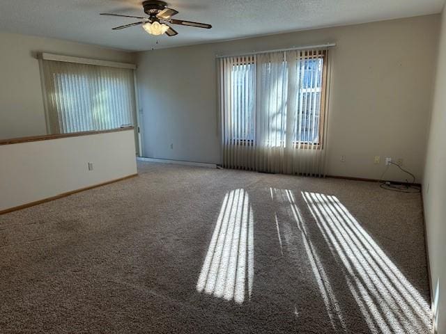 empty room with a textured ceiling, ceiling fan, and carpet