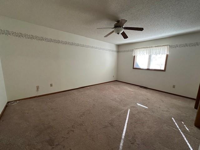 empty room featuring a textured ceiling, carpet floors, and ceiling fan