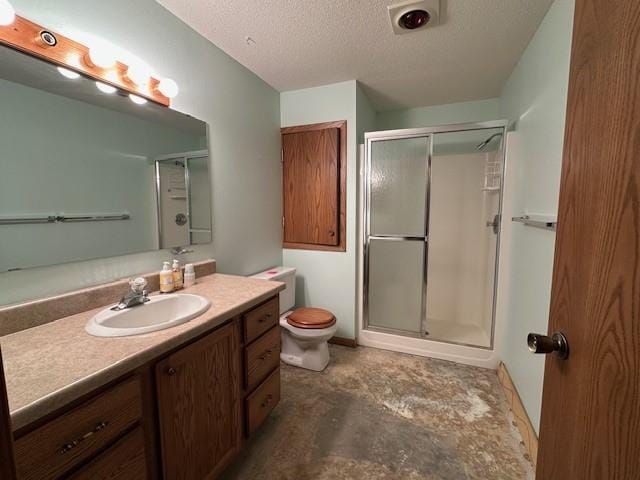 bathroom featuring vanity, an enclosed shower, a textured ceiling, and toilet