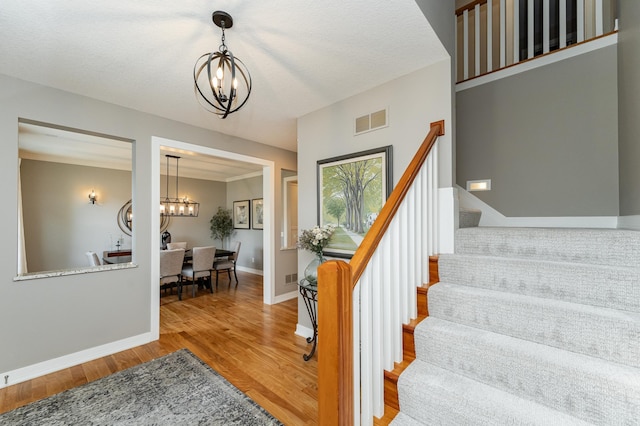 3942 Autumn Lake Ct SW, Rochester, MN 55902 - staircase featuring a chandelier and wood finished floors