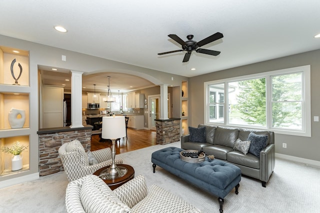 3942 Autumn Lake Ct SW, Rochester, MN 55902 - living room with decorative columns, a ceiling fan, arched walkways, recessed lighting, and light colored carpet