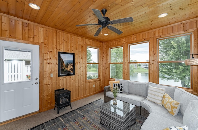 3942 Autumn Lake Ct SW, Rochester, MN 55902 - carpeted living area featuring plenty of natural light, a wood stove, a water view, a ceiling fan, and wooden ceiling