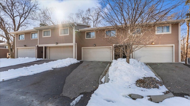 multi unit property featuring a garage and driveway