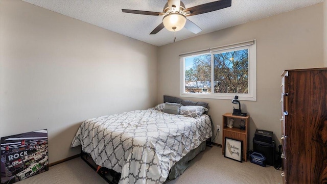 bedroom with ceiling fan, a textured ceiling, baseboards, and carpet floors