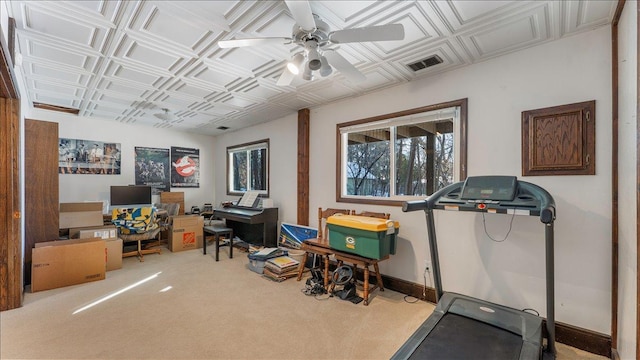 workout room featuring visible vents, ceiling fan, carpet, baseboards, and an ornate ceiling