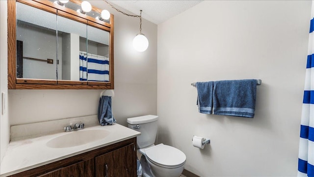 bathroom featuring curtained shower, toilet, vanity, and a textured ceiling