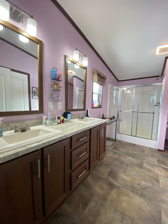 bathroom featuring vanity, lofted ceiling, and a shower with shower door