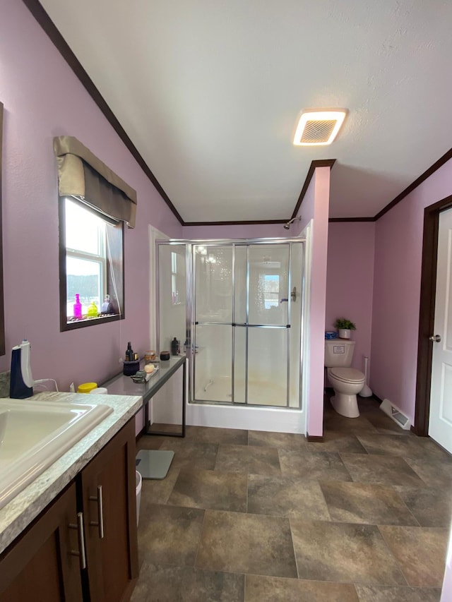 bathroom featuring vanity, crown molding, toilet, and walk in shower