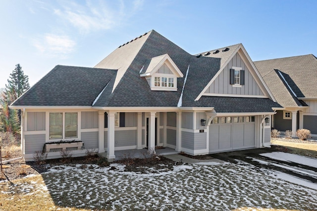 view of front of house featuring an attached garage, covered porch, driveway, roof with shingles, and board and batten siding