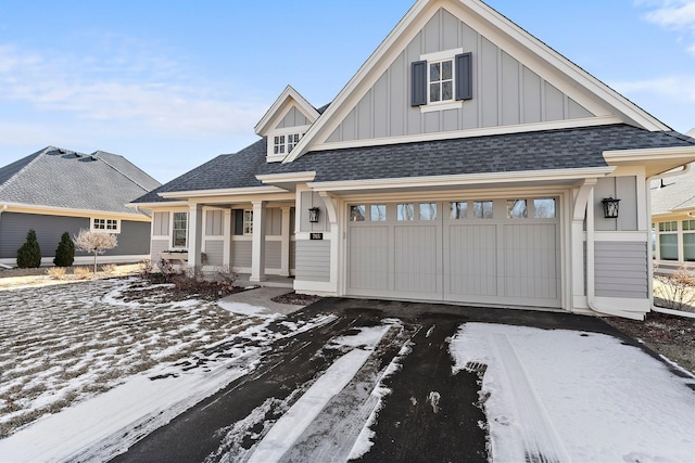 view of front of property with a garage, driveway, roof with shingles, and board and batten siding