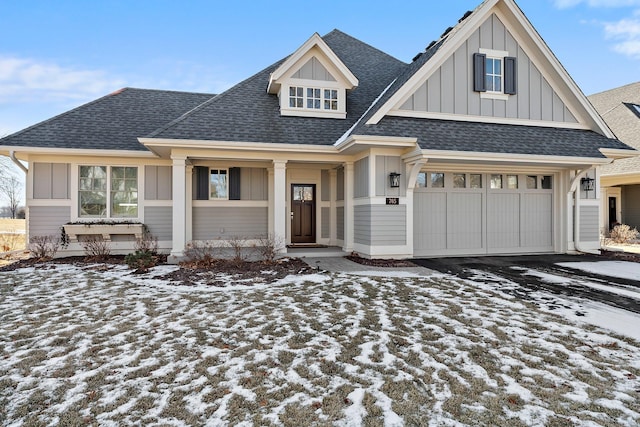 view of front of house featuring a garage, driveway, board and batten siding, and roof with shingles