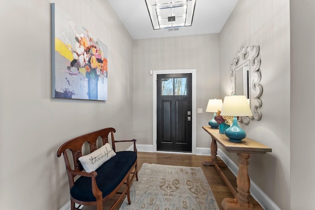 entryway featuring baseboards and wood finished floors