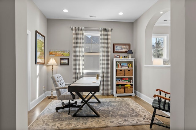 office featuring arched walkways, recessed lighting, wood finished floors, and baseboards