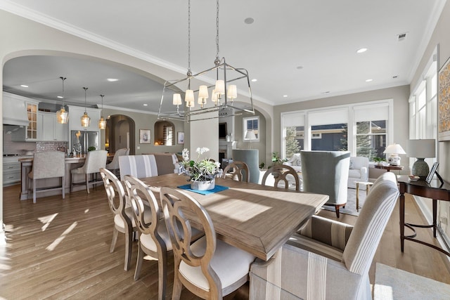 dining area featuring recessed lighting, light wood-style flooring, and crown molding