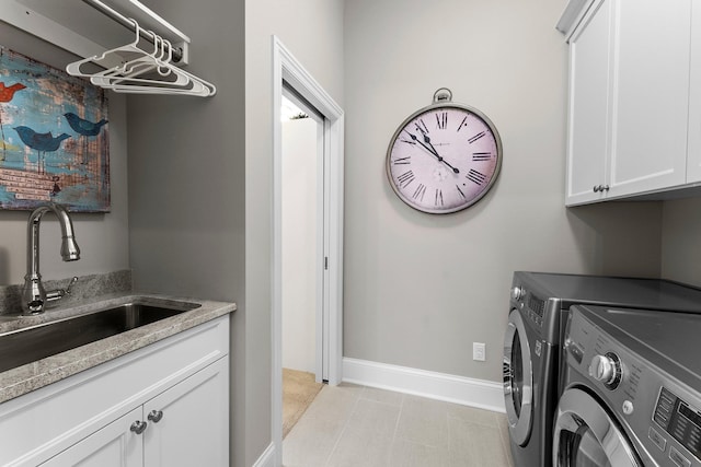 laundry room with independent washer and dryer, cabinet space, a sink, and baseboards