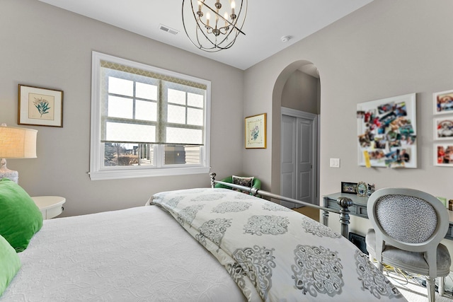 bedroom featuring arched walkways, a closet, a chandelier, and visible vents