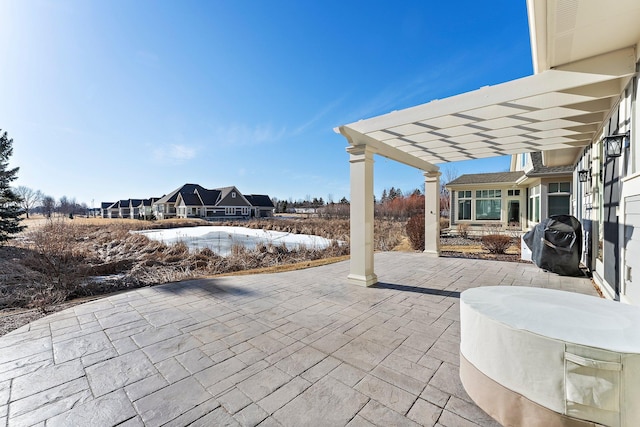 view of patio with area for grilling and a pergola