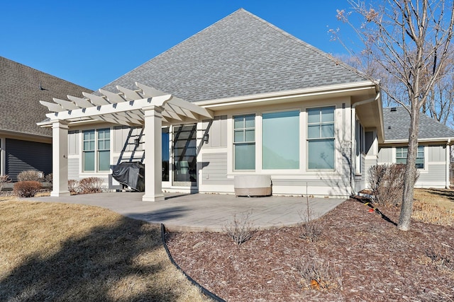 back of house featuring a patio, a pergola, and roof with shingles