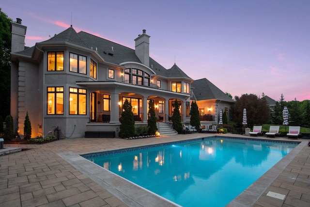 back house at dusk with a patio