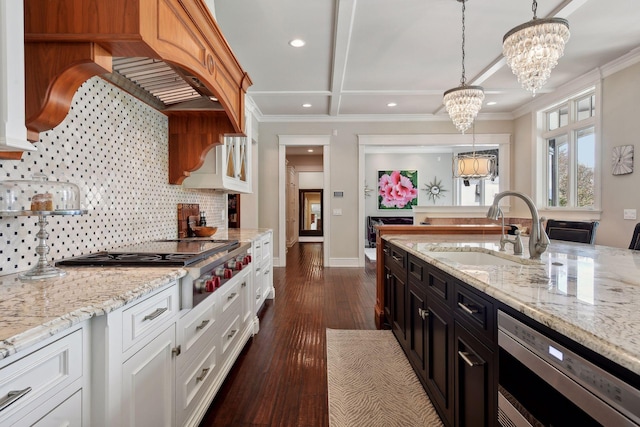 kitchen featuring white cabinetry, sink, light stone counters, and decorative light fixtures