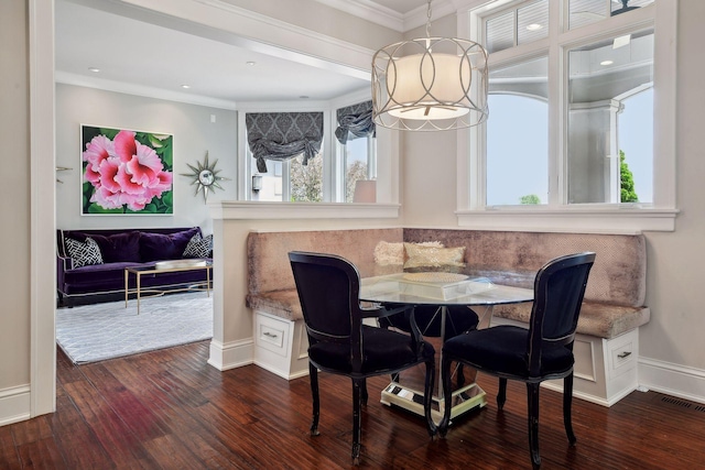 dining space featuring breakfast area, ornamental molding, and dark wood-type flooring