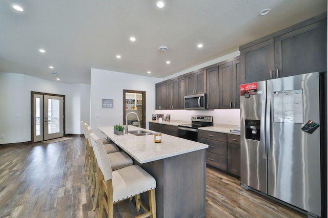 kitchen featuring dark brown cabinetry, appliances with stainless steel finishes, sink, and a kitchen island with sink