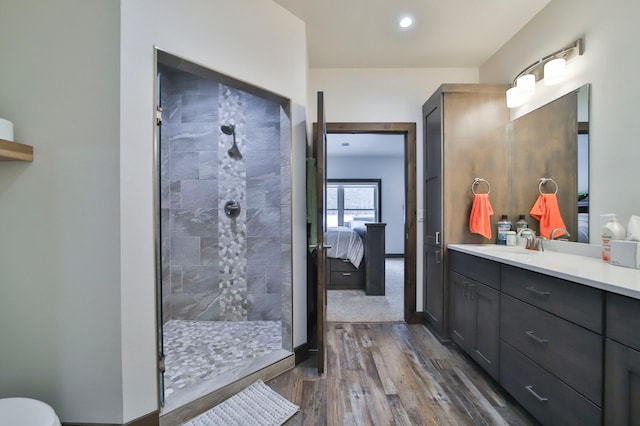 bathroom with vanity, wood-type flooring, and a tile shower