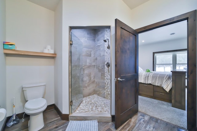 bathroom featuring an enclosed shower, hardwood / wood-style flooring, and toilet