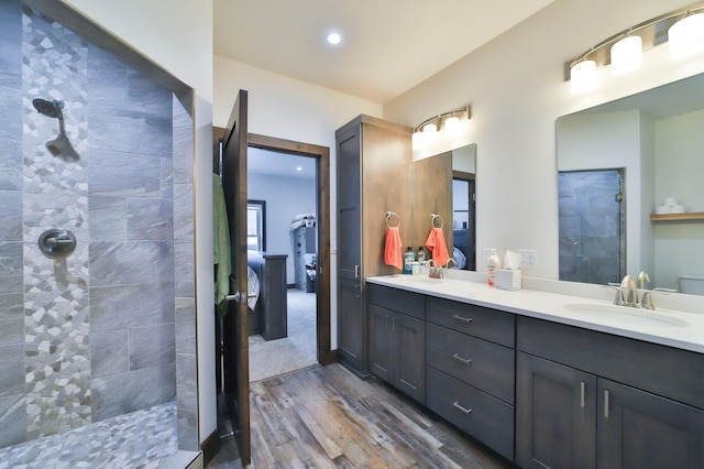 bathroom with vanity, hardwood / wood-style flooring, and a tile shower