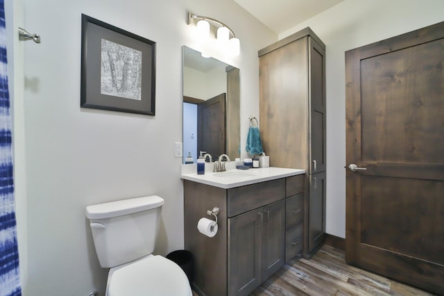 bathroom with hardwood / wood-style flooring, vanity, and toilet