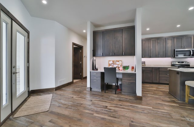 kitchen with stainless steel appliances, dark hardwood / wood-style flooring, and dark brown cabinets