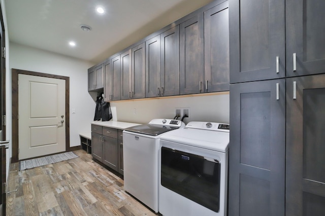 laundry area with independent washer and dryer, cabinets, and light wood-type flooring