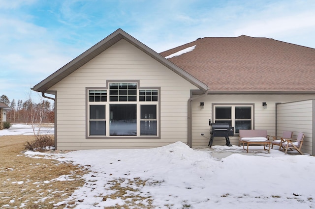 view of snow covered rear of property