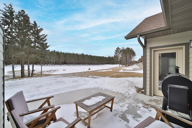 snow covered patio with a grill