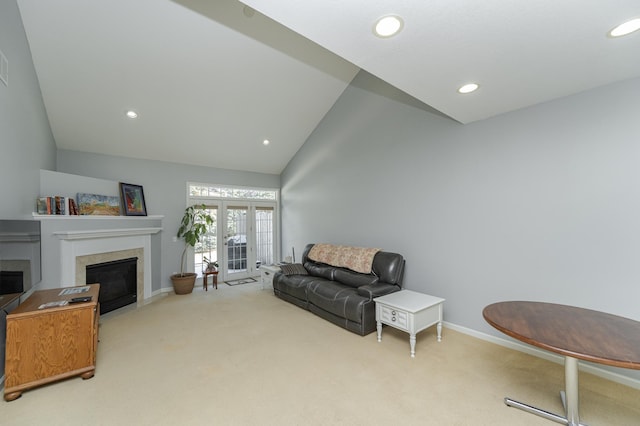 carpeted living room featuring high vaulted ceiling and french doors