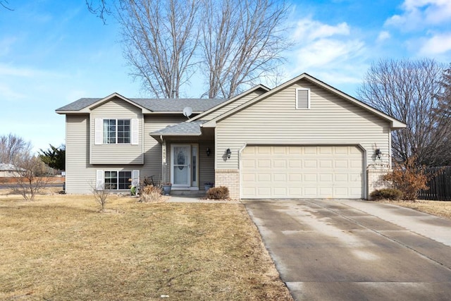 split level home featuring a shingled roof, concrete driveway, an attached garage, a front lawn, and brick siding