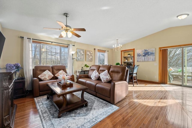 living area with light wood-style floors, baseboards, vaulted ceiling, and ceiling fan with notable chandelier