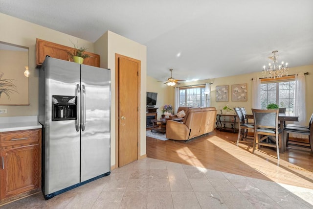 kitchen with brown cabinetry, a healthy amount of sunlight, and stainless steel fridge