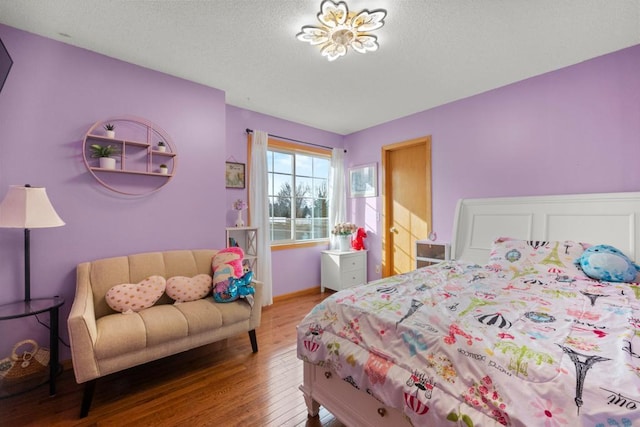 bedroom featuring a textured ceiling and wood finished floors