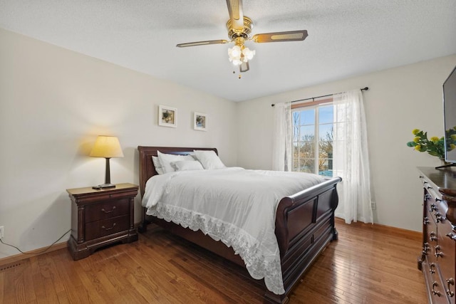 bedroom with ceiling fan, hardwood / wood-style floors, and baseboards