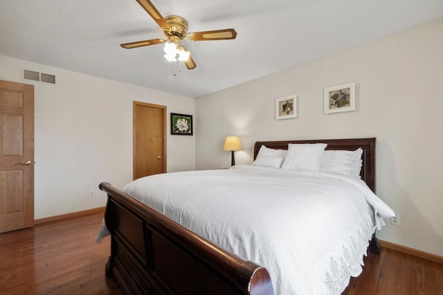 bedroom featuring a ceiling fan, wood finished floors, visible vents, and baseboards