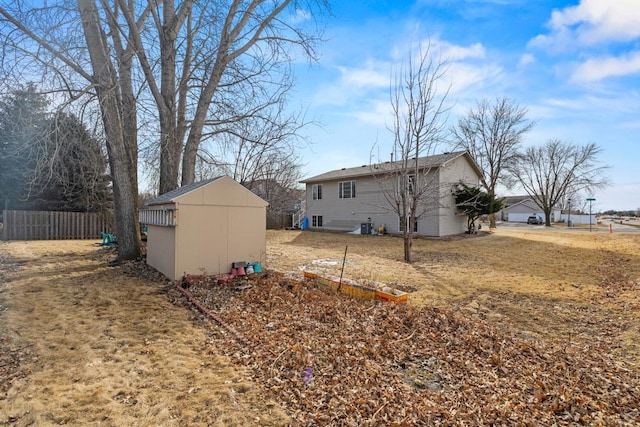 exterior space with a storage unit, fence, and an outdoor structure